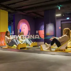 Dwie dziewczyny na wózkach Newtona, świetna zabawa i nauka. To jedne z wielu warszawa atrakcje dla młodzieży.