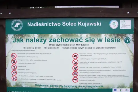 Tablica informacyjna Nadleśnictwa Solec Kujawski z zasadami zachowania w lesie, przypominająca o szacunku do przyrody i innych użytkowników.
