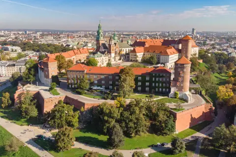 Wawel w województwie krakowskim, zamek i katedra na wzgórzu, otoczone ceglanymi murami i zielenią.