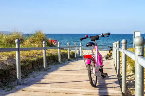 Różowy rower czeka na ścieżce przy plaży. Idealne miejsce na odkrywanie tras rowerowych Władysławowo.