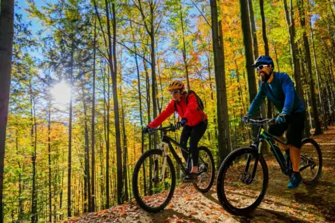 Para rowerzystów cieszy jesienne słońce na trasach rowerowych w Mikołajkach.