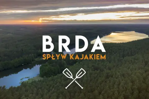 Zachód słońca nad lasem i jeziorem. Napis "BRDA SPŁYW KAJAKIEM" zaprasza na niezapomnianą przygodę. Opis trasy czeka!