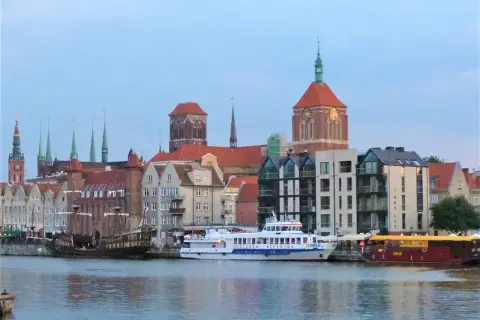 Statek wycieczkowy "Gryf" płynie przez Gdańsk, mijając zabytkowe kamienice i kościoły.