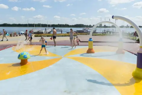 Dzieci bawią się na wodnym placu zabaw przy plaży nad jeziorem Zegrzyńskim.