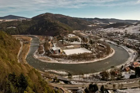 Piwniczna-Zdrój w Beskidzie Sądeckim, z meandrującą rzeką Poprad, ośnieżonymi wzgórzami i zabudowaniami.