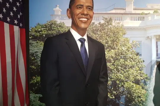 Figurka Baracka Obamy w garniturze, obok flagi USA. Władysławowo muzeum figur woskowych cennik.