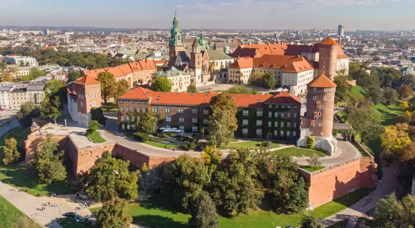 Wawel w województwie krakowskim, zamek i katedra na wzgórzu, otoczone ceglanymi murami i zielenią.