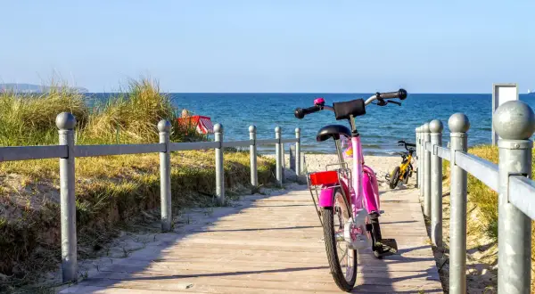 Różowy rower czeka na ścieżce przy plaży. Idealne miejsce na odkrywanie tras rowerowych Władysławowo.