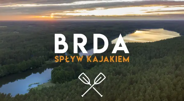 Zachód słońca nad lasem i jeziorem. Napis "BRDA SPŁYW KAJAKIEM" zaprasza na niezapomnianą przygodę. Opis trasy czeka!