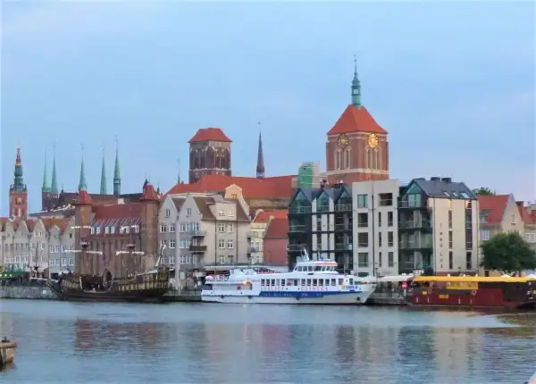Statek wycieczkowy "Gryf" płynie przez Gdańsk, mijając zabytkowe kamienice i kościoły.